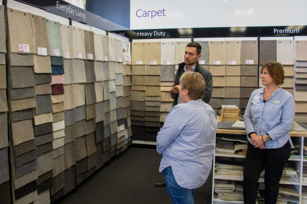 Flooring expert giving design advice while looking at carpet samples